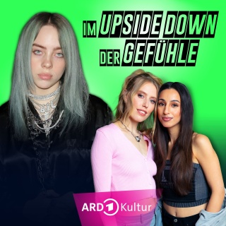 Links im Bild: Billie Eilish mit silber-grauem Haar, vielen verschiedenen Ketten um den Hals und im schwarzen Samtumhang. Rechts daneben der Schriftzug "im Upside Down der Gefühle" und darunter die Hosts LEA und Gizem Celik
