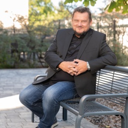 Wirtschaftsjournalist und Investigativreporter Uwe Ritzer sitzt auf einer Bank in einem Park.