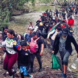 Menschenmassen durchqueren einen Fluß auf der Dschungelroute.